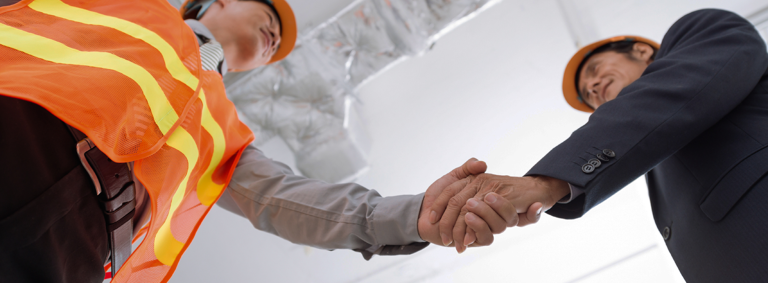 Construction man and businessman shaking hands